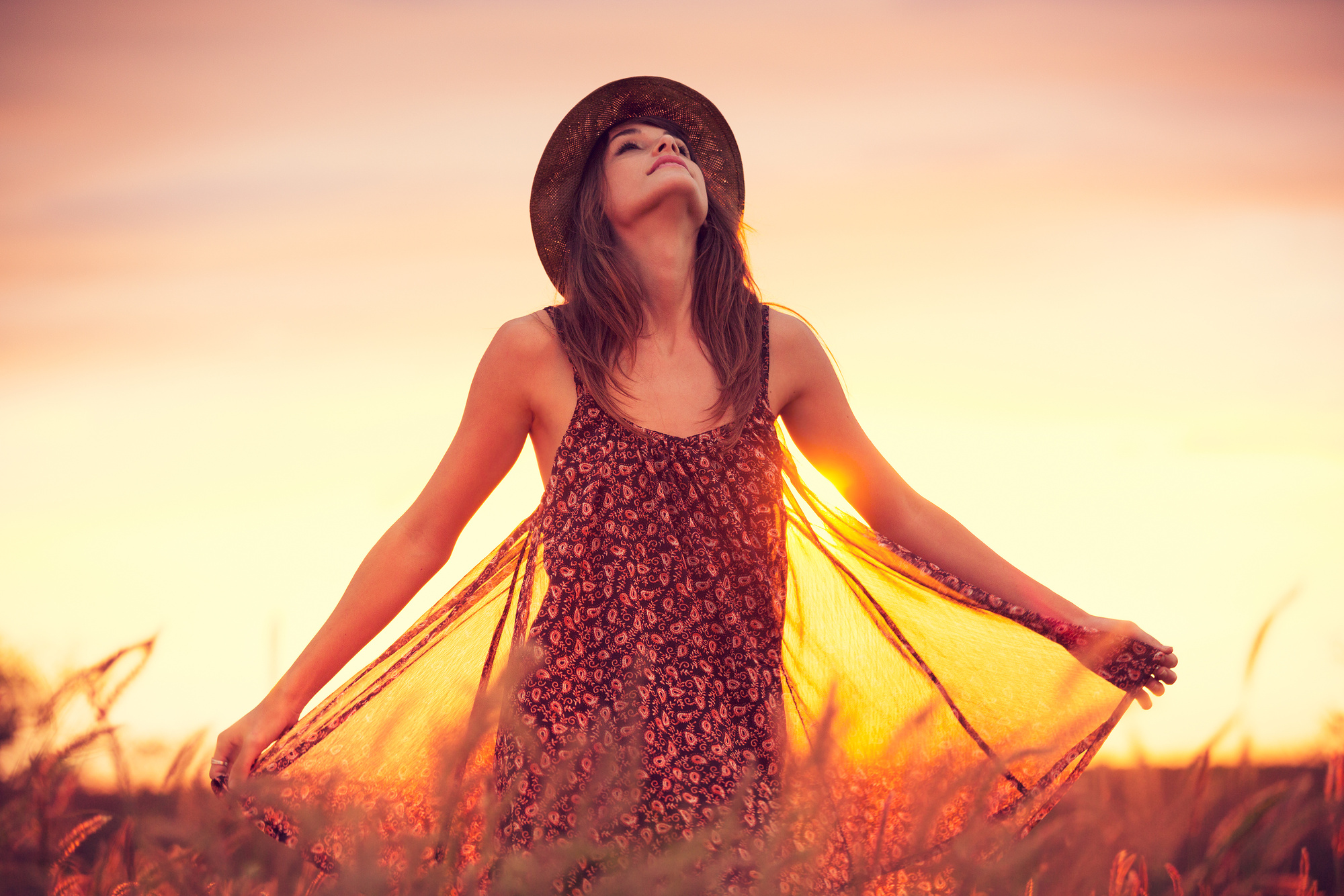 Beautiful Woman in Golden Field at Sunset